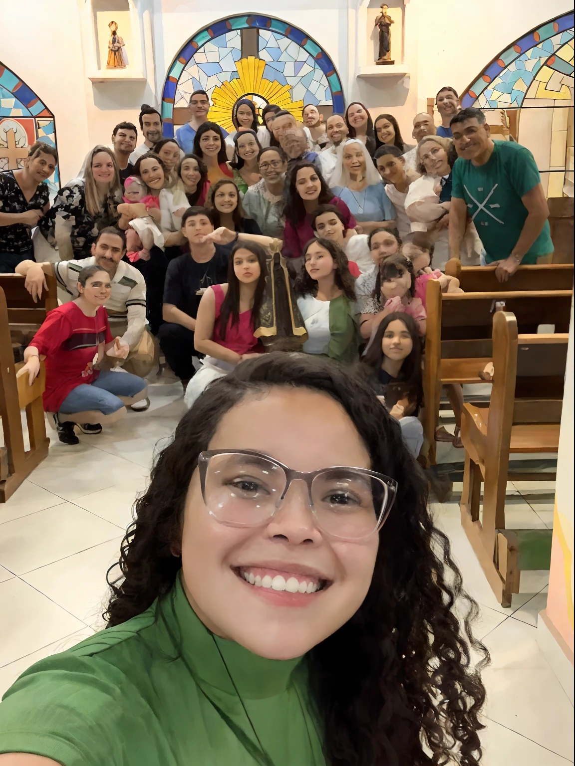 grupo de pessoas sentadas em uma igreja, foto sentido selfie, com nossa senhora Aparecida