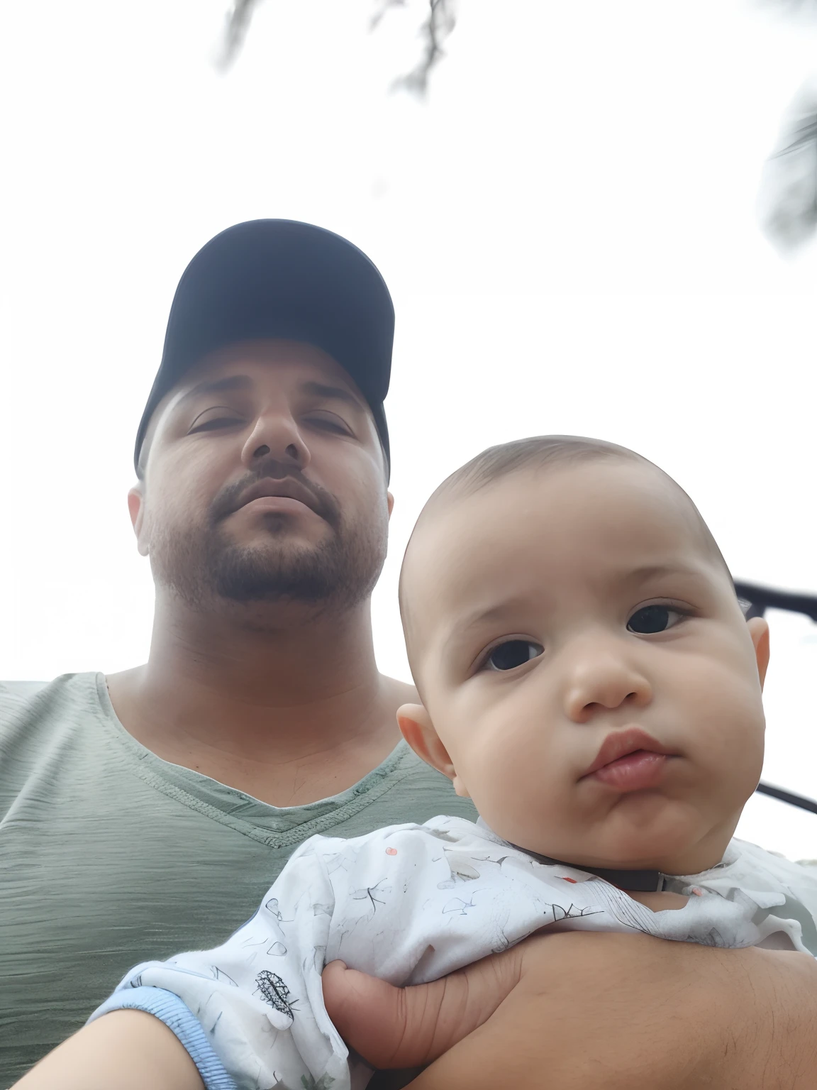 there is a man holding a baby in his arms, papai/paterno, JoSan Gonzalez e Tyler Edlin, papai, pai com filho, Jose Miguel Romano Francisca, imagem de qualidade muito baixa, papai que, imagem de perfil, testa larga paterna carinhosa, serious faces, River in front of you, Selfie, with a kid, looking serious