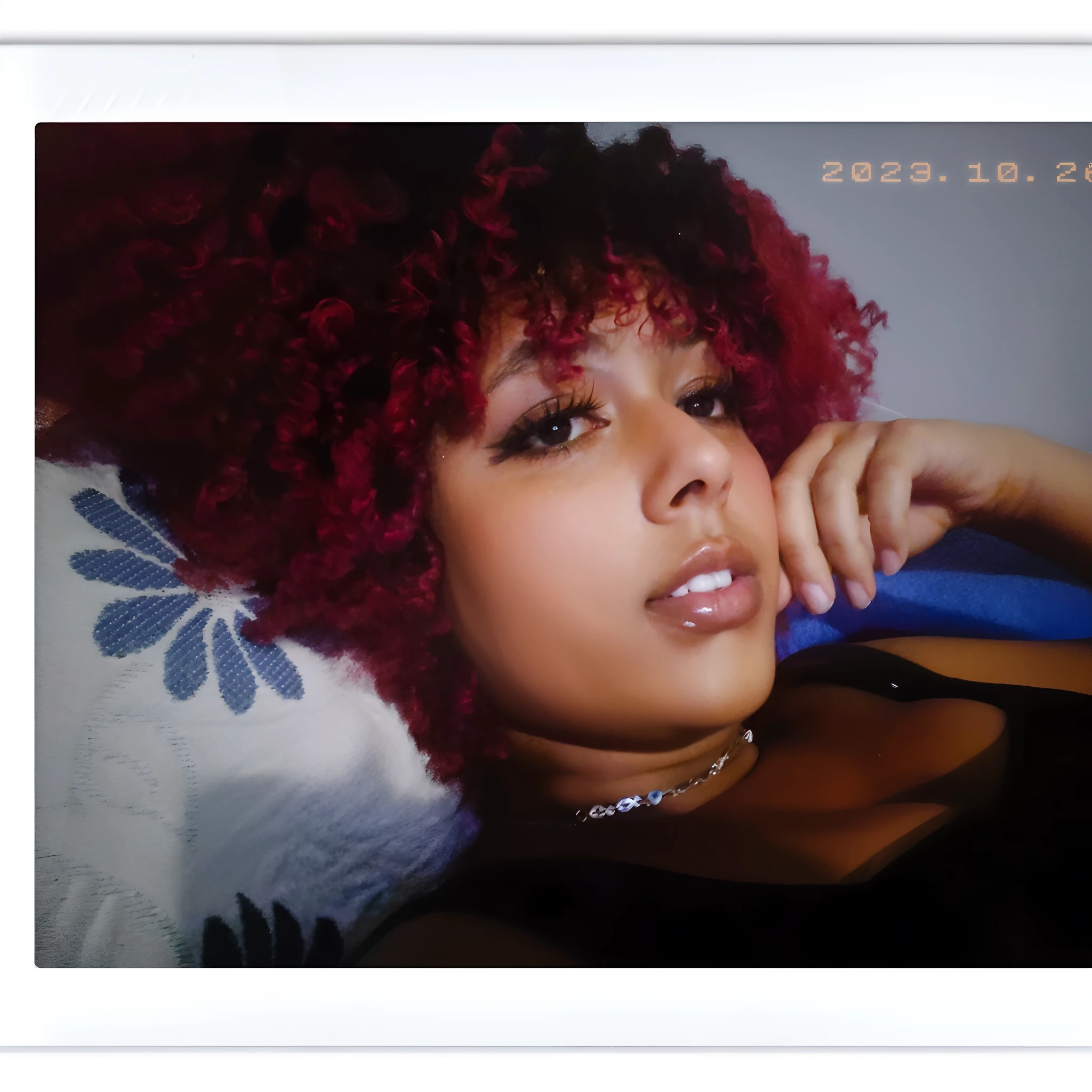 there is a woman with red hair laying on a bed, com cabelos ruivos cacheados, Afro vermelho, tiradas em 2022, cabelos cacheados vermelhos, tomada em 2 0 2 0, seu rosto emoldurado com cachos, cabelos ruivos cacheados, peruca vermelha, com cabelos ruivos, fotografia de baixa qualidade, Afro vermelho grande, with red haze, Cor vermelha, ela tem cabelos ruivos