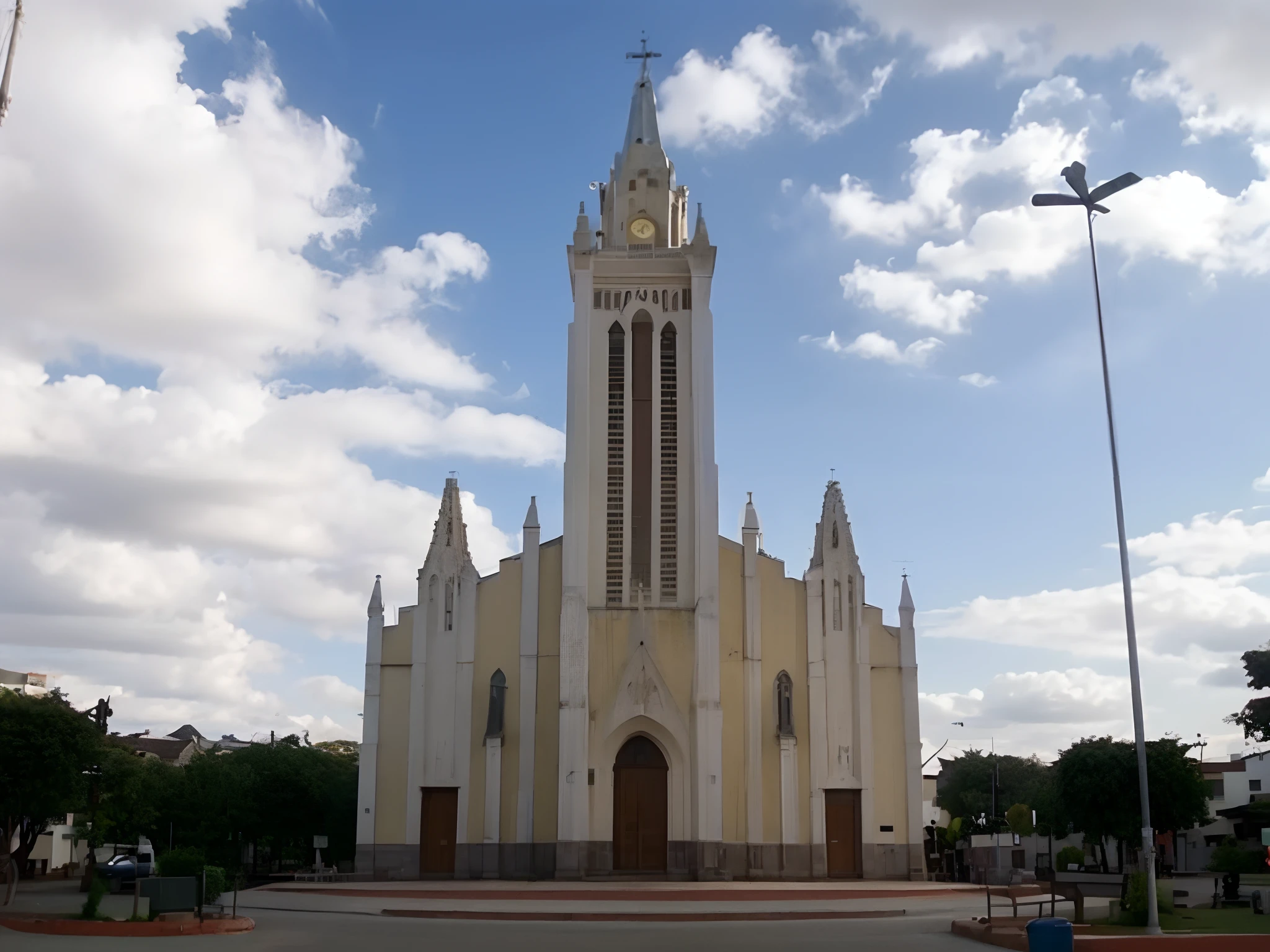 A church in a public square, a igreja tem uma torre central, cor amarela com detalhes brancos, portas marrons