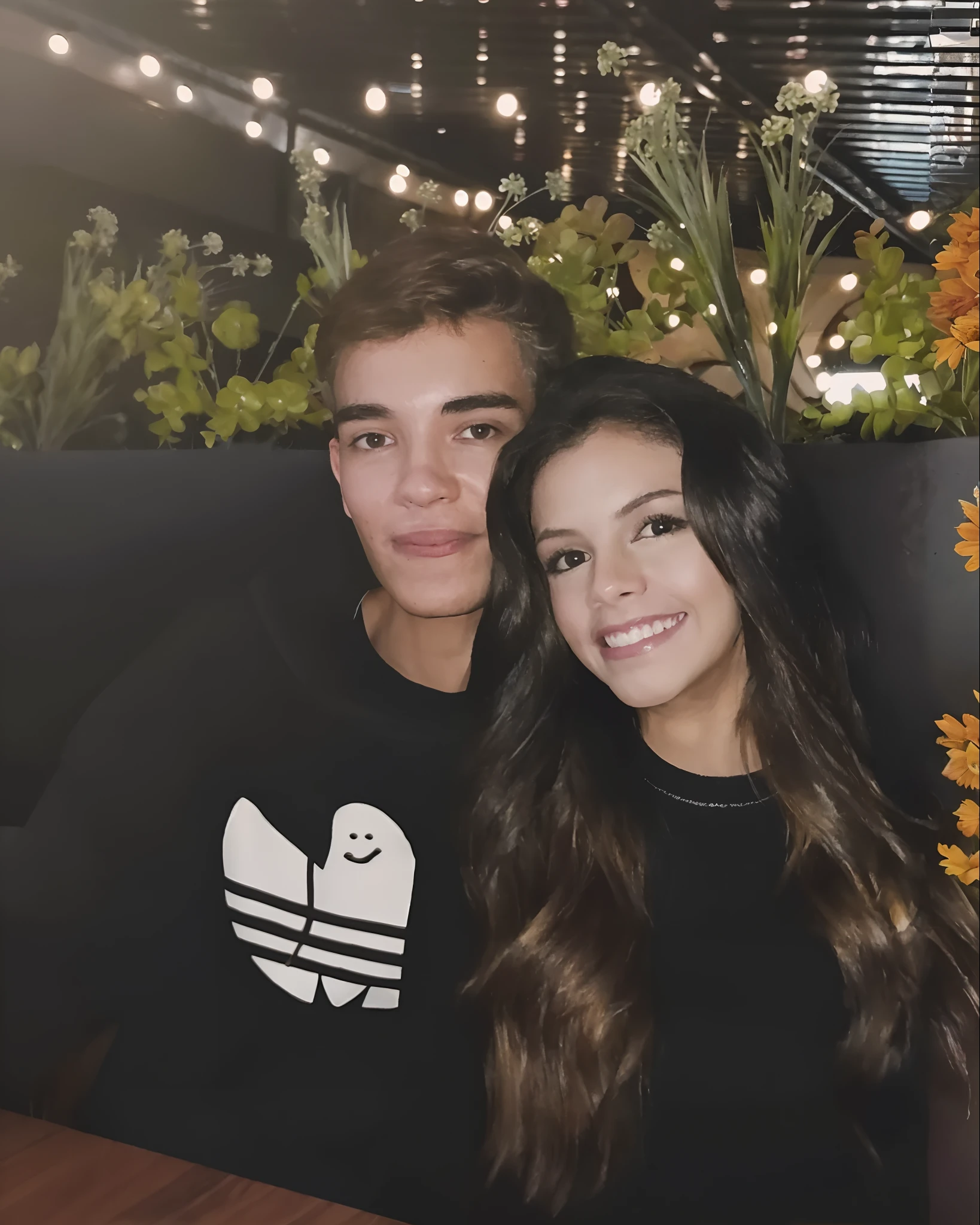 Casal Arafed sentado em uma mesa com plantas ao fundo, they are siblings, Cerveja Madison, Cerveja Soft Devil Queen Madison, julia fuentes, inspired by John Luke, they are in love, :: Cerveja Madison, They are close to each other, by John Luke, 📷 Mungojerrie e Rumpleteazer, Jordan Grimmer e Natasha Tan