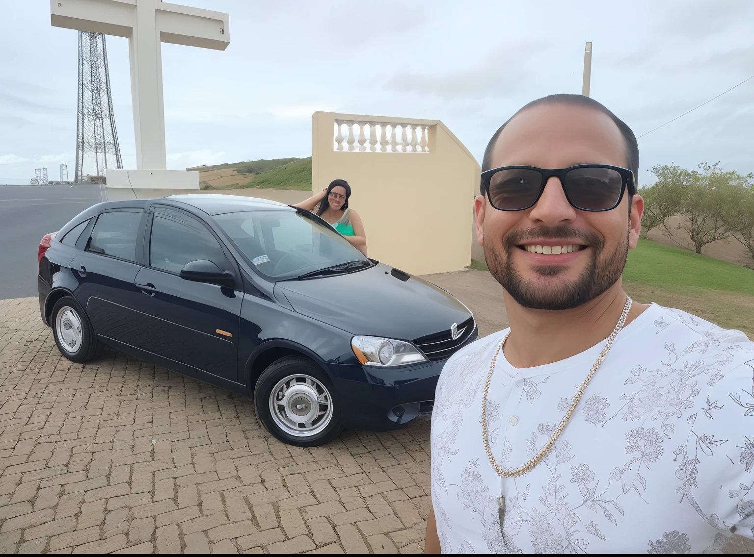 There is a man with glasses taking a selfie together with his wife and his car in a beautiful place. Homem de 35 s e mulher de 28, ambos muito felizes.