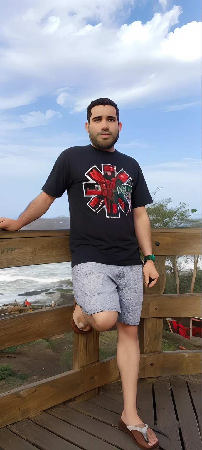 Jovem loiro com olhos verdes fazendo pose em frente ao mar