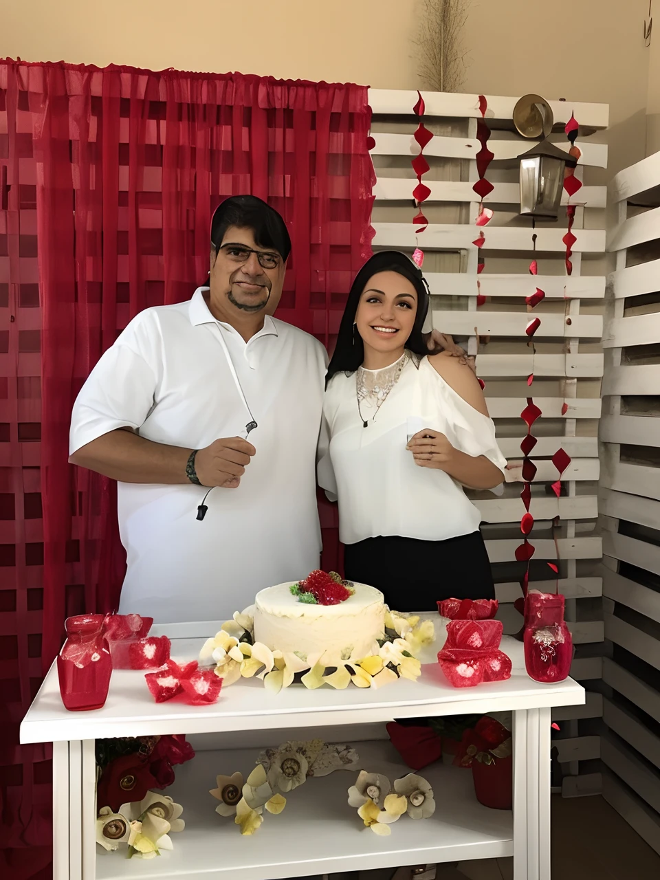 They are posing for a photo with a cake and red decorations, celebrar um casamento ilegal, Casal feliz, imagem de perfil, Lovely couple, Directed by: Márta Lacza, he is! cerca de 3 0 anos de idade, Directed by: Glòria Muñoz, Directed by: Nandor Soldier, momma and papa, Alex Flores, tema de cores vermelho e branco