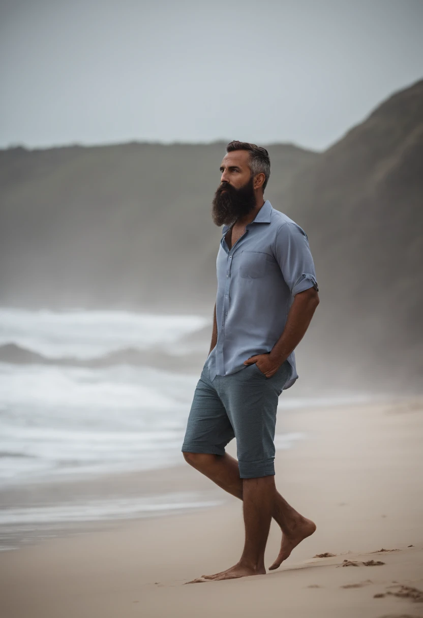 Homem Sentado na praia de camisa cinza e barba curta olhando o horizonte