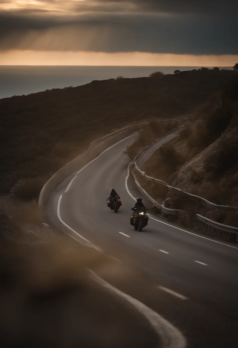 some motorcyclists riding their bikes down a winding road between the seaside mountains heading towards the sun. Sunset with cloudy sky.