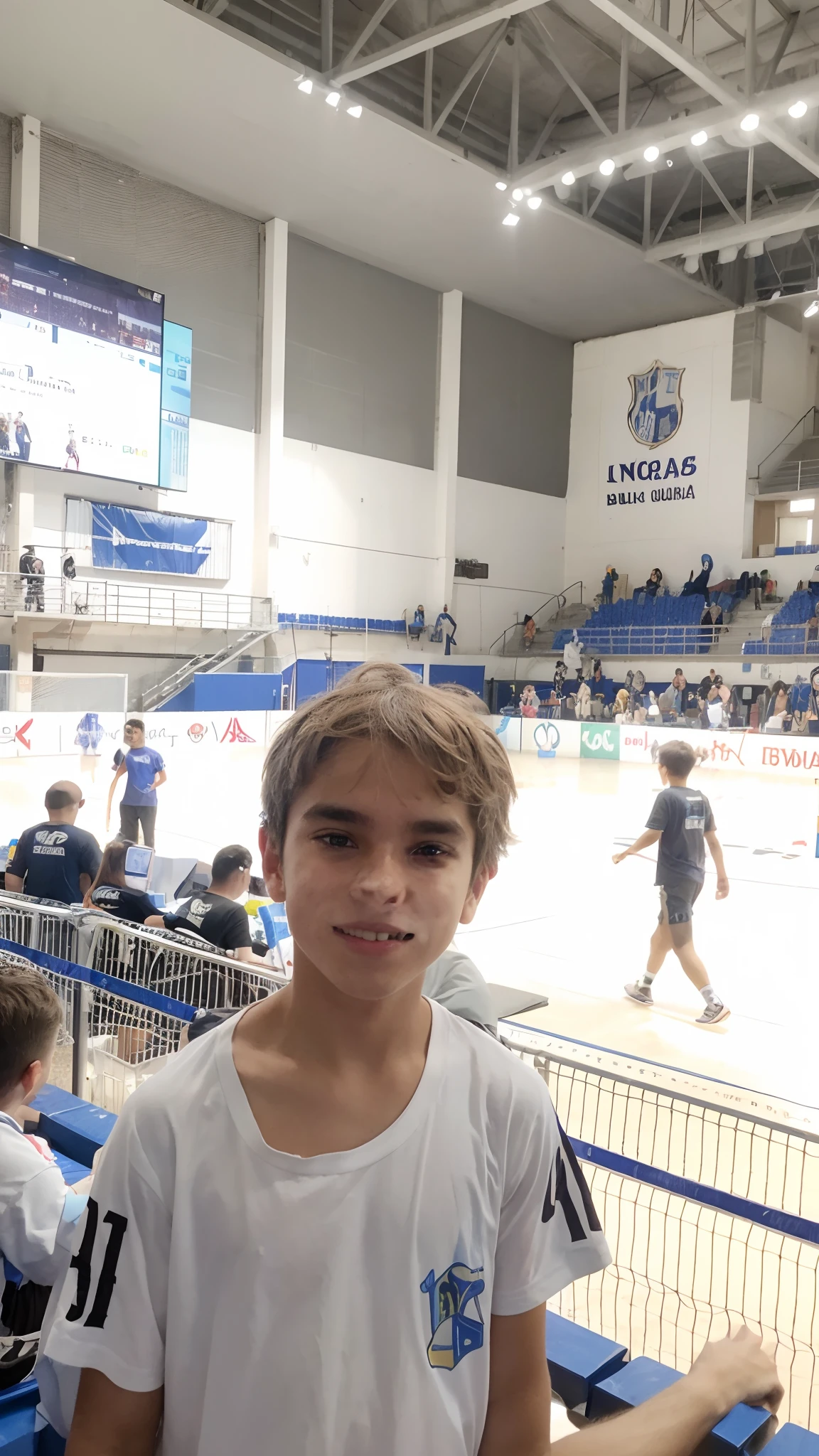 Menino de 06 anos, bonito, alegre e sorridente, louro com cabelos lisos e dourados com blusa branca e ao fundo uma quadra de futsal