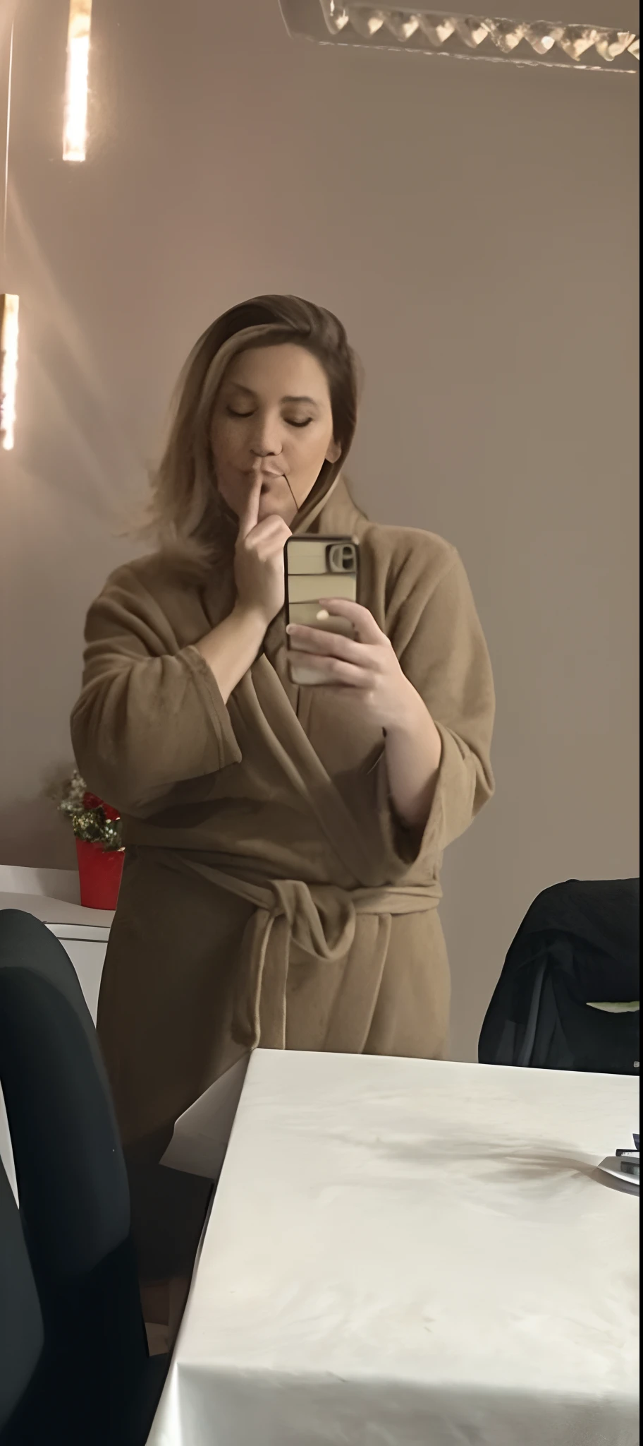 Mulher loira com cabelos molhados segurando o celular