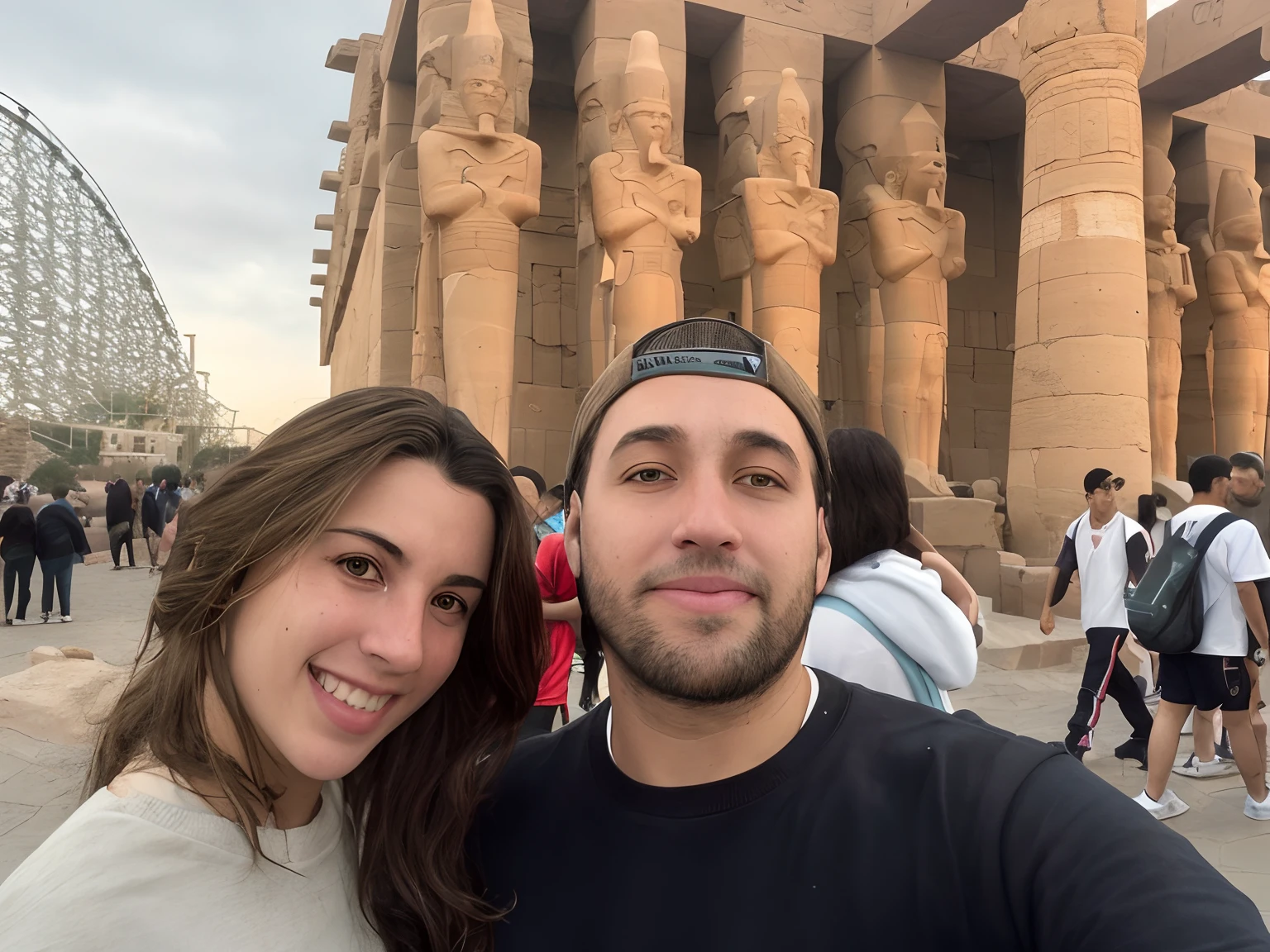 There are two people in front of a large building, No Egito, Luxor, do Egito, Ruins in the background, in giza, em uma cidade antiga, em frente ao templo, De Luxor, Ancient ruins in the background, In the background, An amusement park in Ancient Egypt, em frente a um templo, pyramids in the background