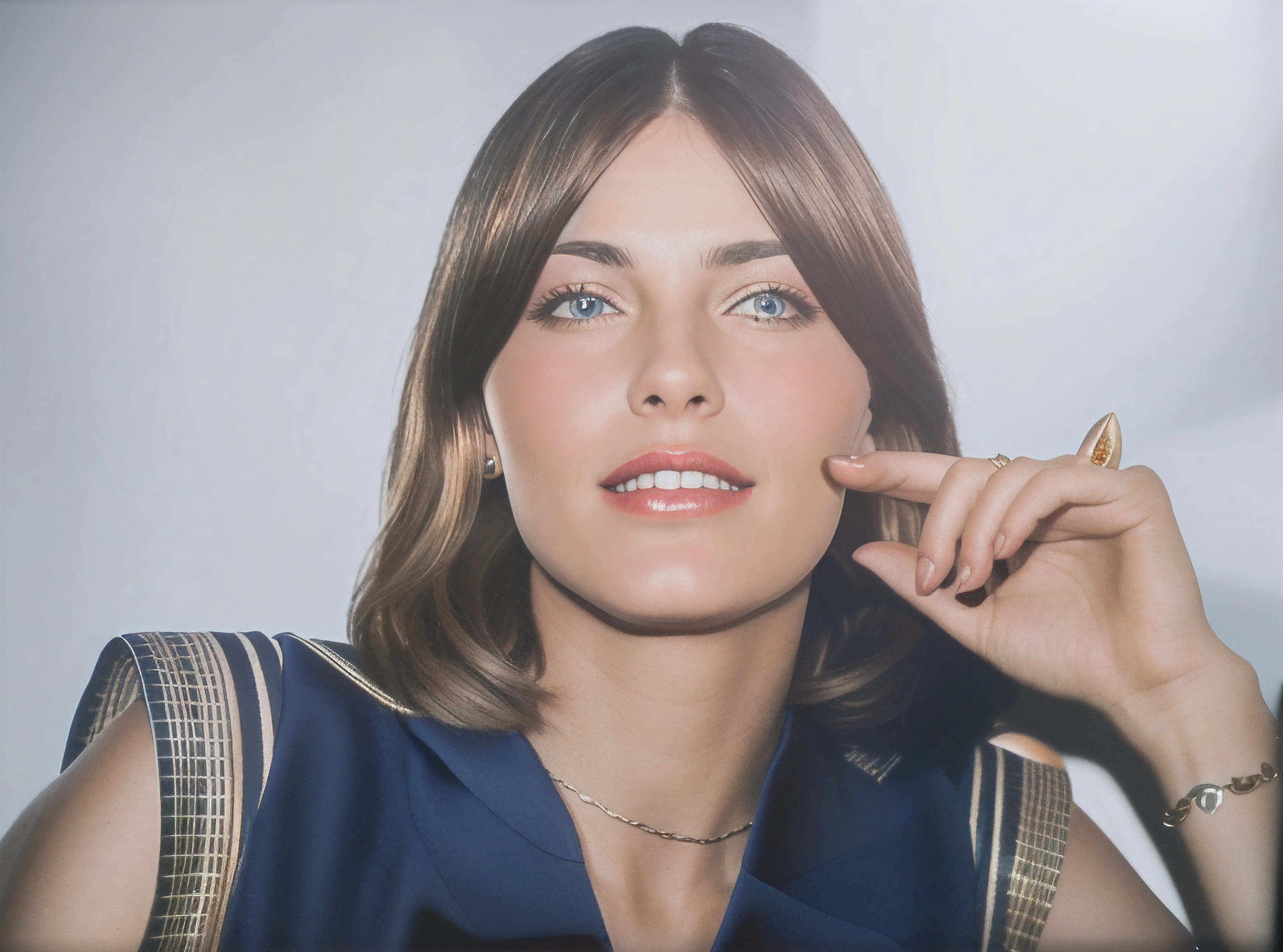 Mulher de cabelo castanho claro, olhos castanhos, usa um vestido azul, wears a gold thread around his neck, It has a white diamond ring and a gold bracelet on its arm