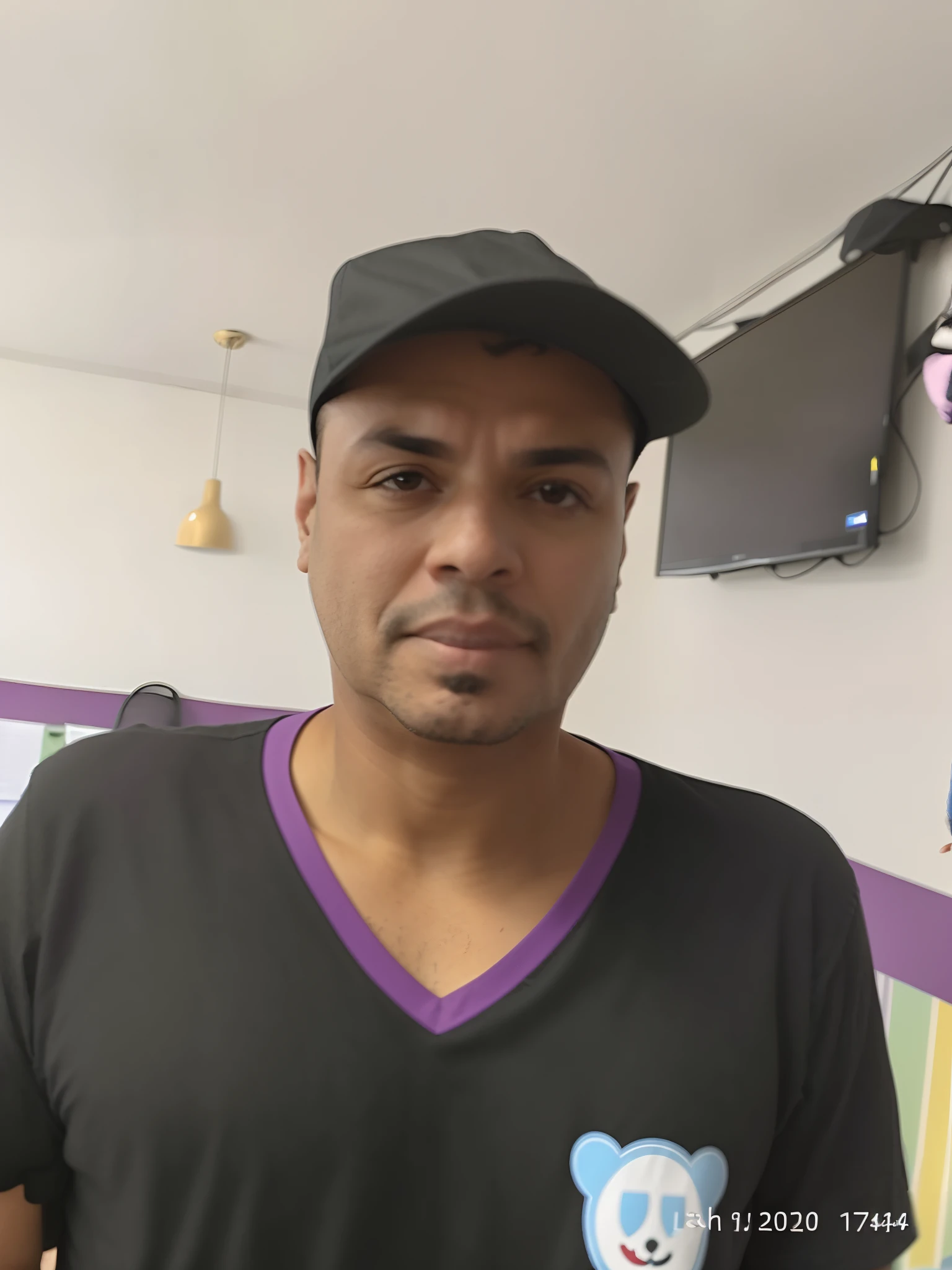 There's a man in a black shirt and a black hat, taken in the early 2020s, Parece Fabiula Nascimento, wearing a purple cap, ele tem cerca de 50 anos, ele tem cerca de 5 0 anos de idade, taken in the late 2010s, he is wearing a black t-shirt, david rios ferreira
