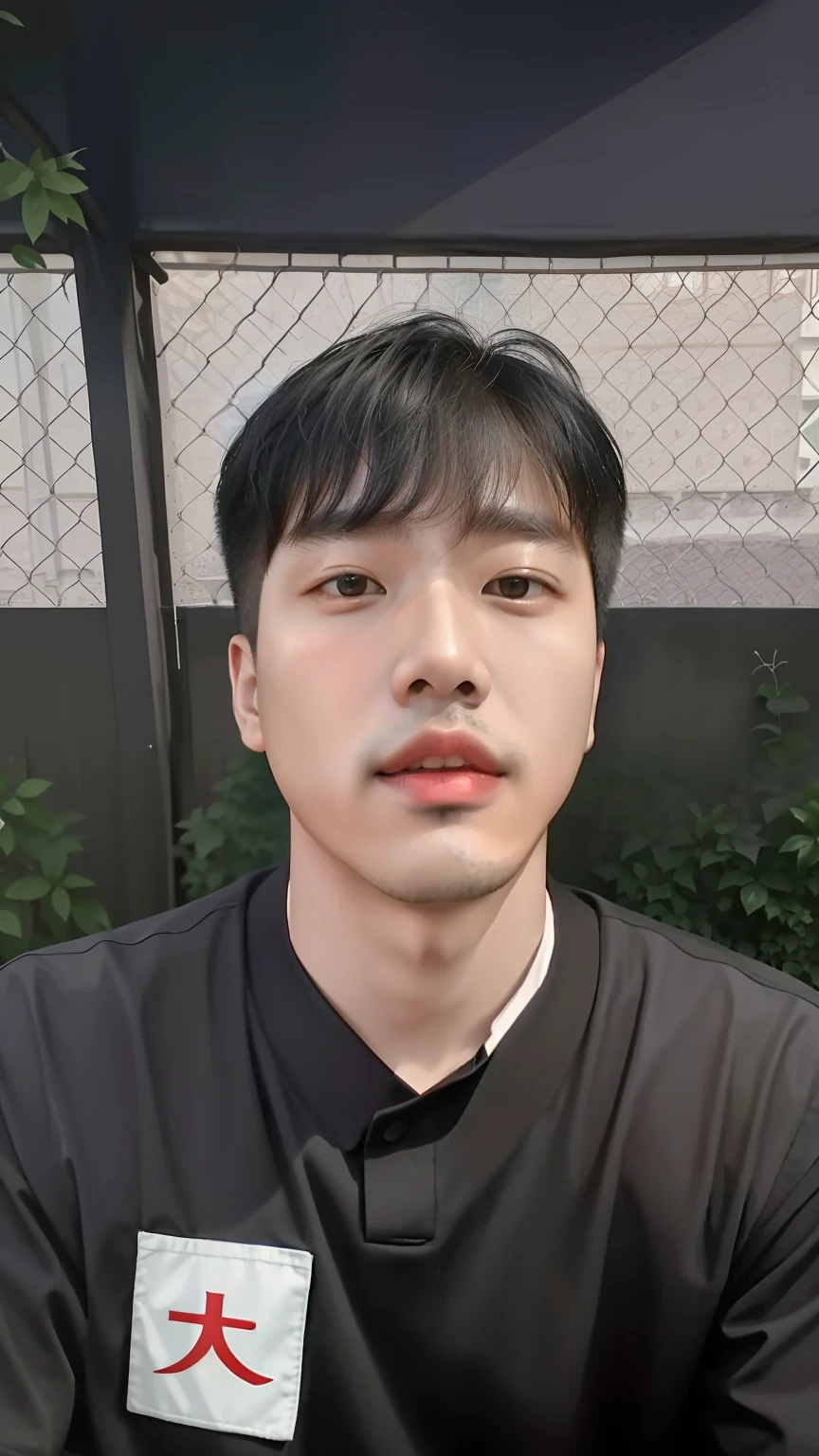 A Chinese man in a black shirt sits in front of a fence, Zhongyuan Zheng Lei, Kim Tae-joon, taken in the early 2020s, Sweaty face, 25 age old, South Korean male, 2 3 years old, jeremy cheung,, paul kwon, reuben wu, joongwon jeong, Shin Jung-ho