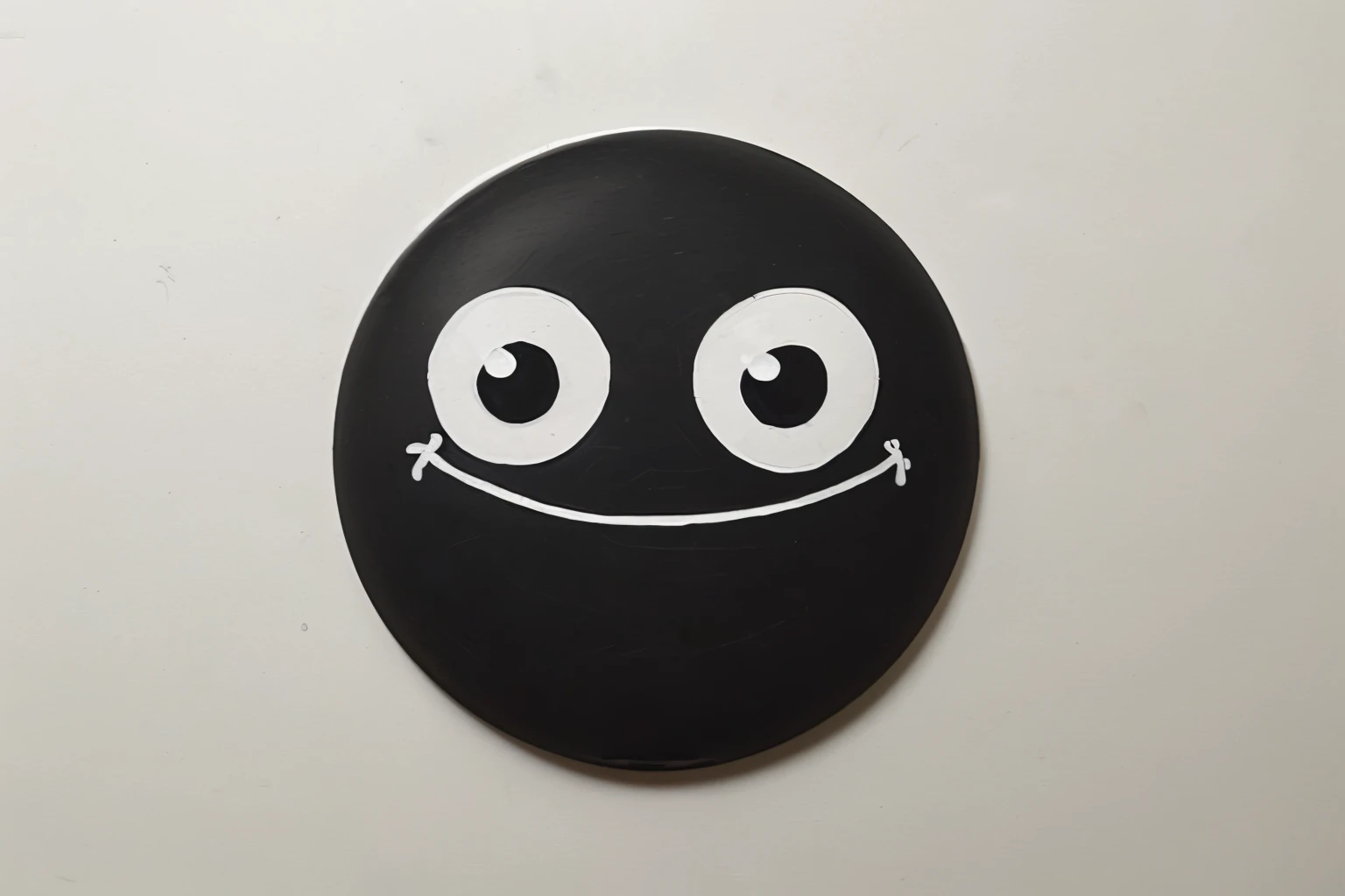 a rounded black circle with 2 white draw eyes, a sad mouth drawn in white too