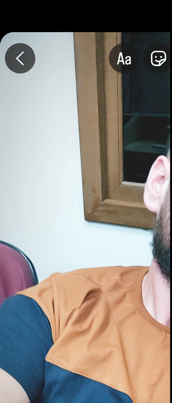there is a man with a beard and a bearding sitting in a chair, barba encerada, barba marrom curta, vestindo uma camiseta laranja, barba marrom grossa, barba despenteada, barba arrumada, barba de barba, barba marrom, barba curta, barba curta e desgrenhada, barba marrom desgrenhada, barba bem aparada, vestindo uma camiseta