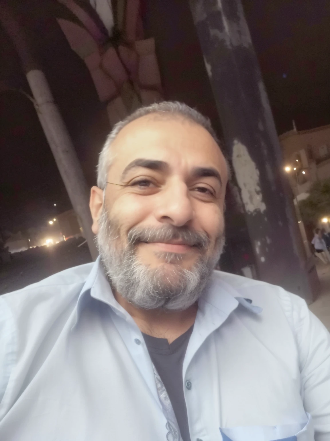 homem com barba e camisa cinza sentado em uma cadeira, Emad Mostaque, taken in the early 2020s, foto selfie, muito feliz!, Ahmad Merheb, ele tem cerca de 45 anos de idade