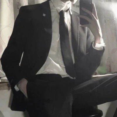 There is a man in a suit sitting on the stool., he is wearing a suit, wearing a strict business suit, Strict suit, Wear a suit and tie, Wear a suit and tie, wearing his suit, Wearing a black suit, dark suit, wear suit!, dressed in a suit, wearing black suits, dressed in a suit, wearing black suits