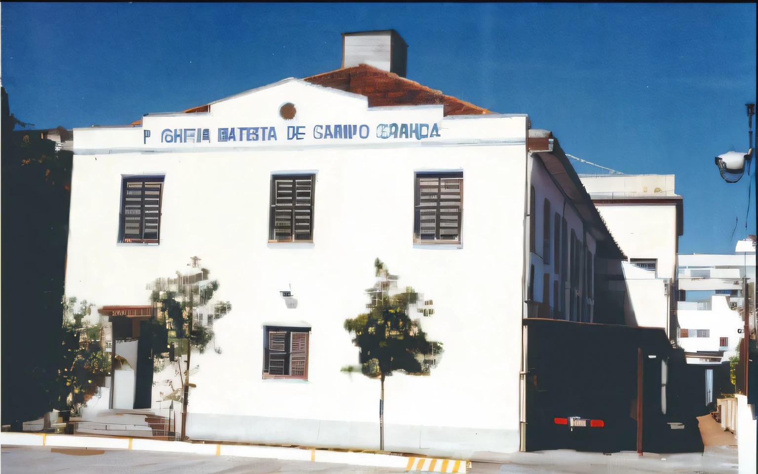 there is a white building with a sign on it that says hospital santaita de campo grande, centre image, academia, historical image, hospital, grainy image, quito school, exterior view, old building, front view 1 9 9 0, historical photograph, exterior shot, fujita goro, clean image, 1990s photograph, bispo do rosario