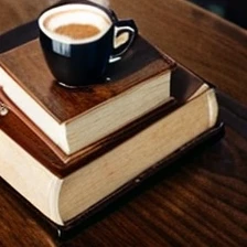 Table with books on top and cup of coffee on the table