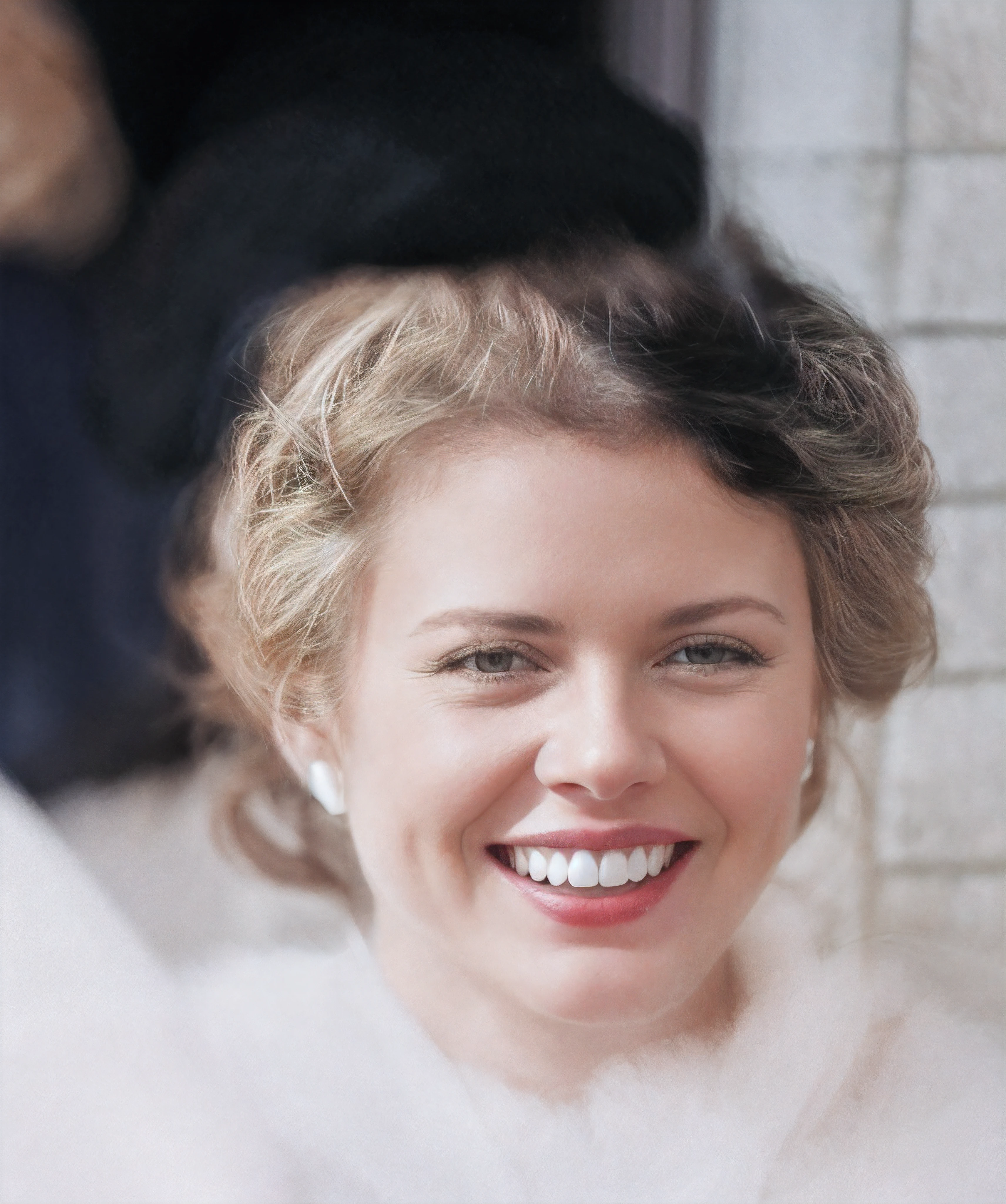 There's a woman who's smiling, cabelo loiro, black nylon scarf on hair