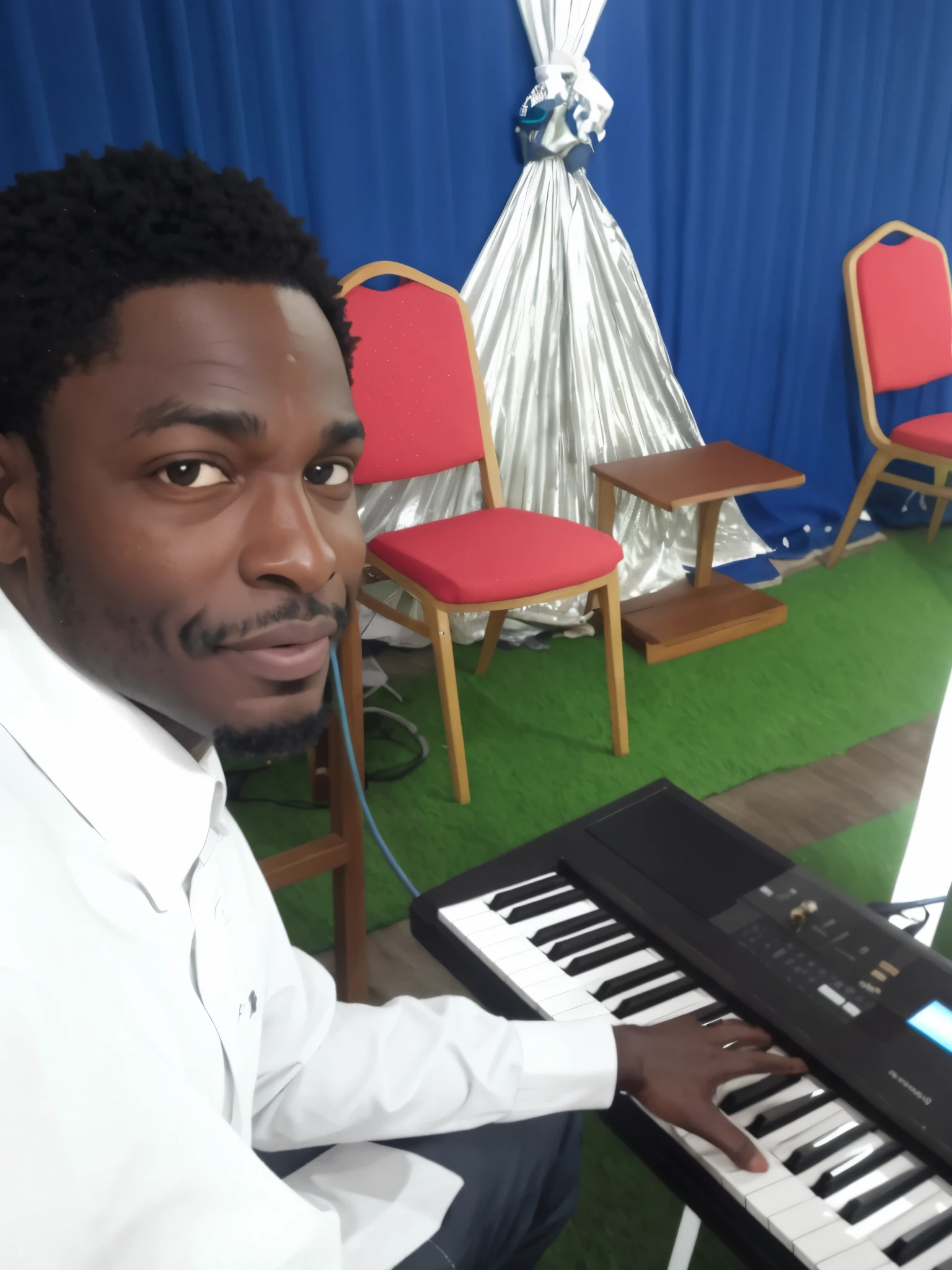 menino sentado em frente a um teclado em frente a um palco com cadeiras, tecladista, pianista, Godwin Akpan, album photo, ambiente tranquilo, Emmanuel Shiru, masterful composition!!!, Usando sintetizador, jamming to music, the god of music, na igreja, ele tem cerca de 20 anos, ele tem cerca de 2 0 anos de idade, tocando piano, Jovem Deus Todo-Poderoso