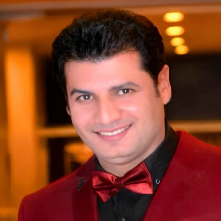smiling man in red suit and bow tie standing in a room, ahmad merheb, eytan zana, mohamed chahin, amr elshamy, sam nassour, farid ghanbari, hicham habchi, sayem reza, enes dirig, richard taddei, jamel shabbaz, mohamed reda, nekro petros afshar