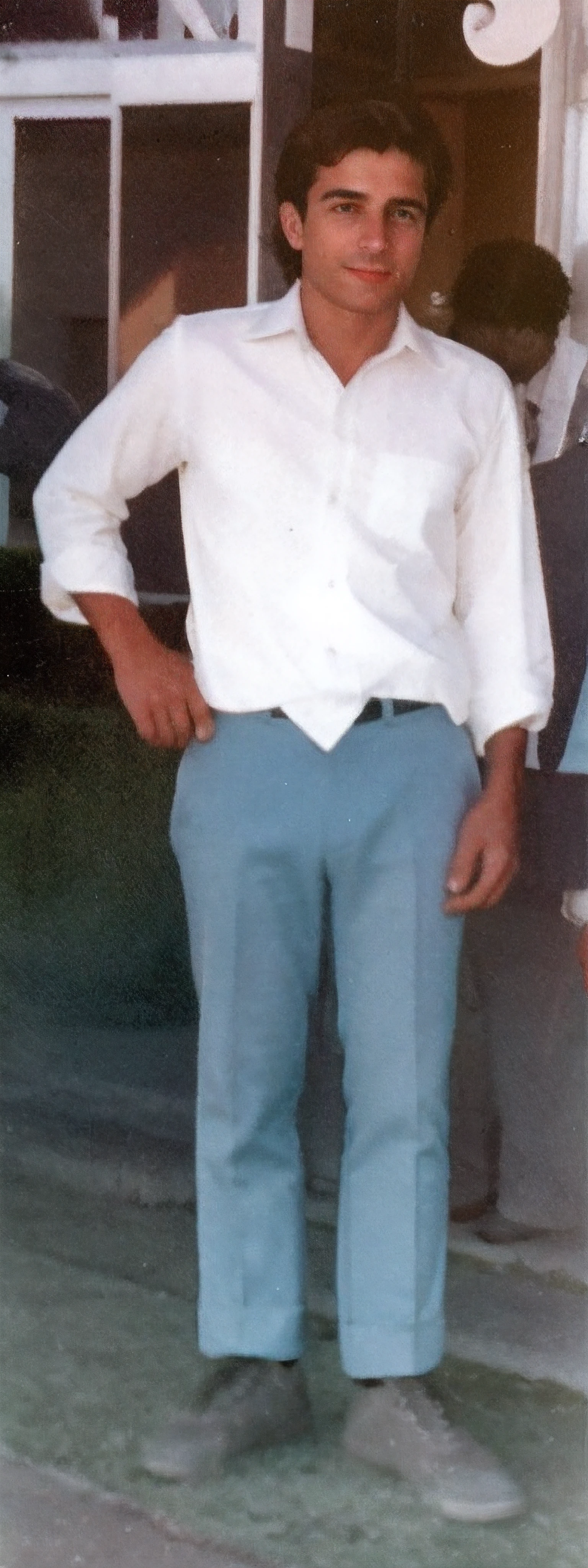 fit man with white shirt and blue pants in front of a building, taken in the early 1990s, wearing pants, foto de um homem, tiradas no final dos anos 1980, tiradas em meados dos anos 2000, with his hands in his pockets, foto granulada de um homem feio, em torno de 1 9 anos