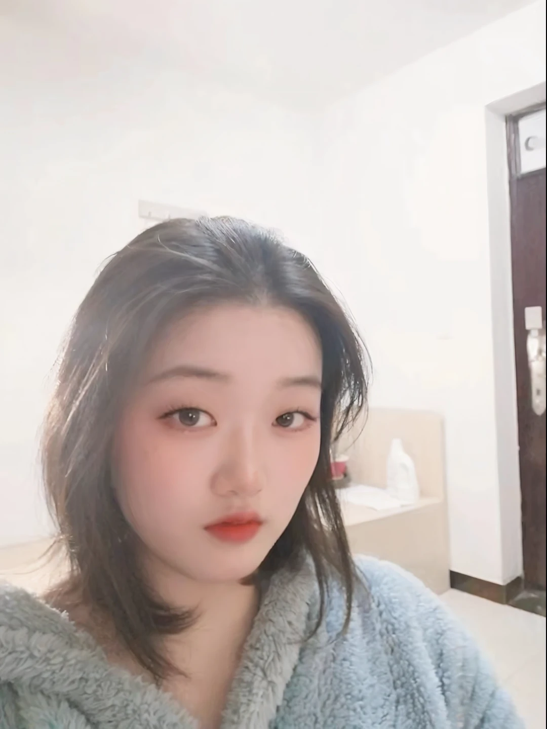 There  a woman wearing a robe posing for a photo, 19 year old girl, 8K photos, xintong chen, Young cute asian face, Pale round face, with a round face, F / 1. 9 6. 8 1 mm large 4 0, she has a cute face, wenFei ye, zmenzheng
