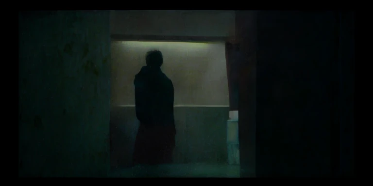 Fed man standing in dark room looking out the window, cinematic ligh《artill, Ethereal stills, screenshots from movies, Still from the movie, Still in the movie, stills from movies, movie frame still, Still from music videos, Art House Film Aesthetics, Still from live-action movies, Still from L'Estate