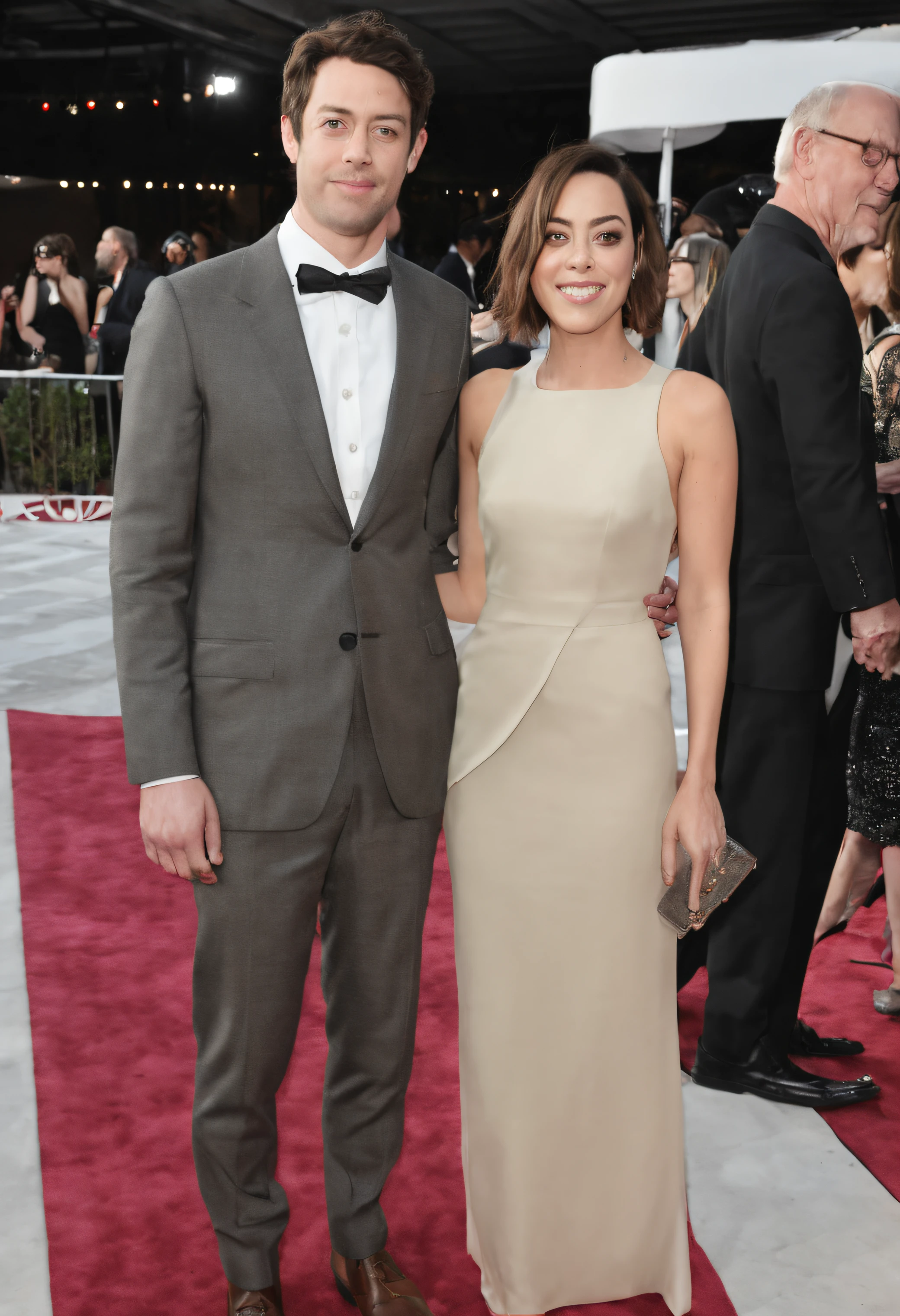 Aubrey Plaza hand to hand with handsome unknown man at a gala