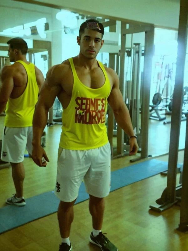 there is a man standing in front of a mirror in a gym, Corpo de Ernest Khalimov, usando camiseta regata, foto de perfil, Fisiculturista Ernest Khalimov, em forma, usando uma camiseta regata, vestindo regata e bermuda, imagem de perfil, vestindo uma camiseta muscular, tiro de corpo inteiro!!, corpo inteiro;, Usando : Tampo do Tanque, foto vazada, joe alves