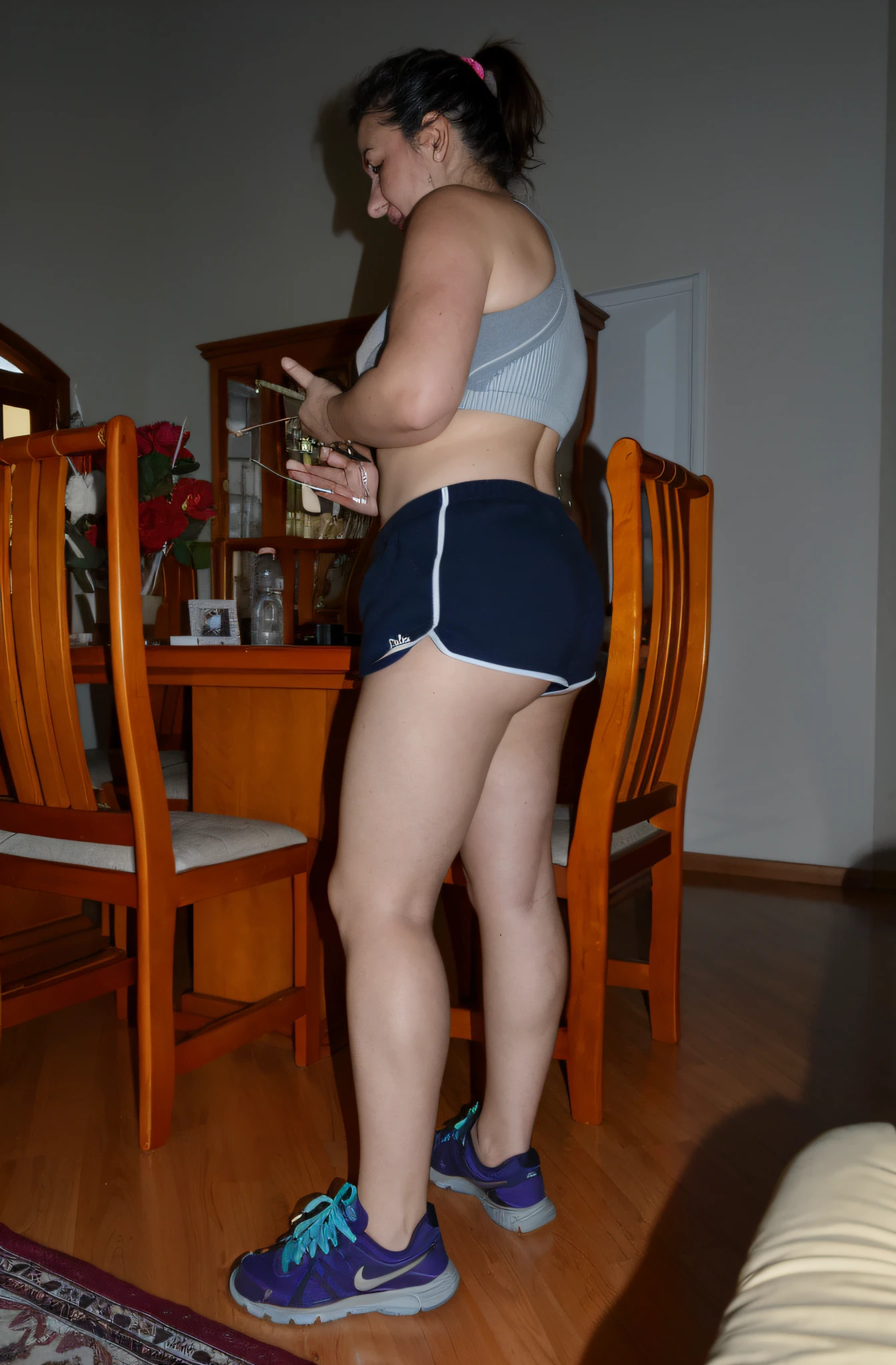 there is a woman standing in a room with a cell phone, sport bra and dark blue shorts, Bermuda, Tiro lateral, coxas expostas!!!, legs visible, coxas expostas, pose lateral, pernas grossas, legs and arms, pernas tonificadas, tiro na perna e coxa, coxas!!!! gorgeous, coxas nuas!!!, tiro na perna e no quadril, coxas!!!!!!, tiro longo de costas