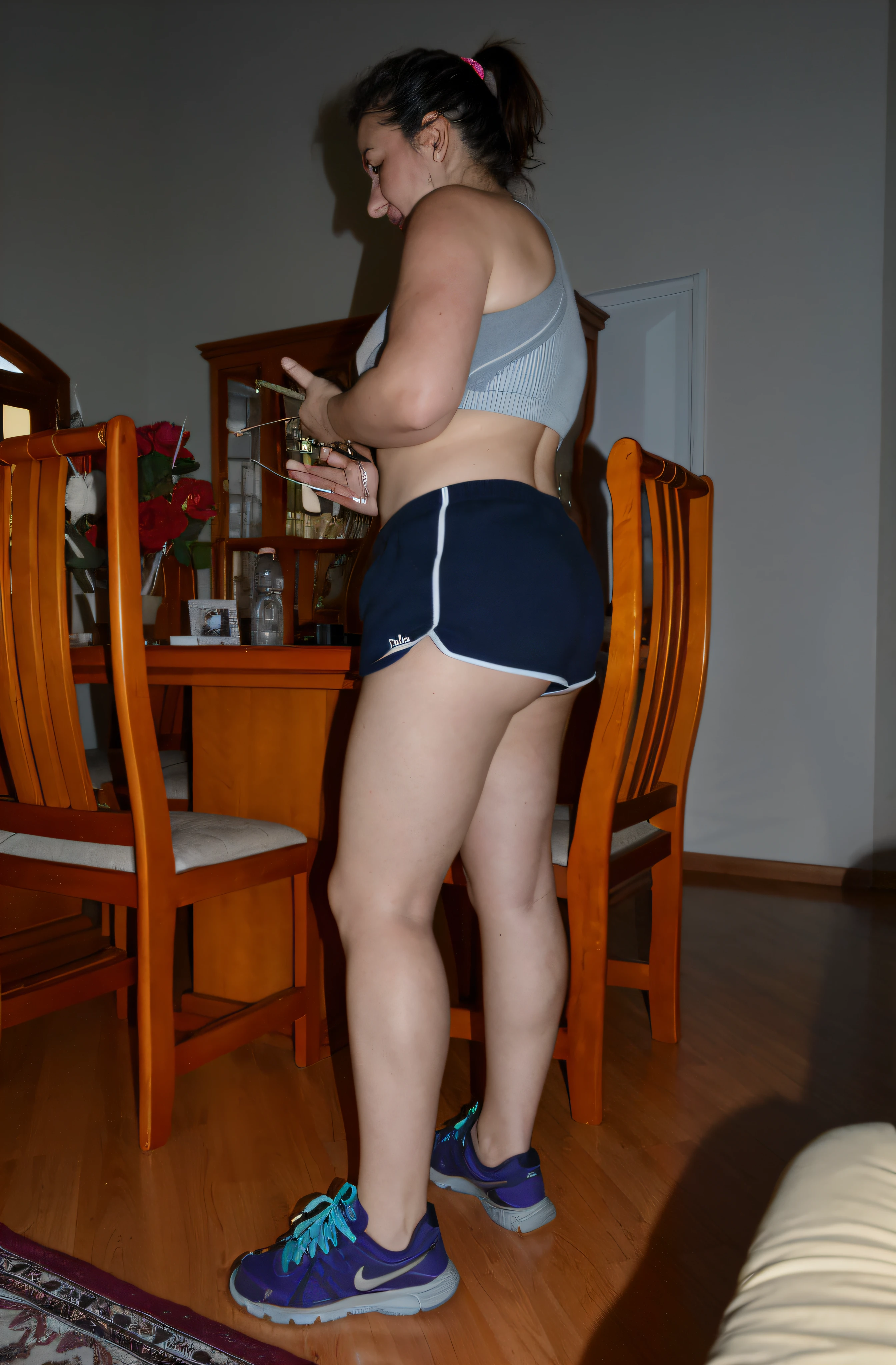 there is a woman standing in a room with a cell phone, sport bra and dark blue shorts, Bermudas, Tiro lateral, coxas expostas!!!, legs visible, coxas expostas, pose lateral, pernas grossas, legs and arms, pernas tonificadas, tiro na perna e coxa, coxas!!!! gorgeous, coxas nuas!!!, tiro na perna e no quadril, coxas!!!!!!, tiro longo de costas