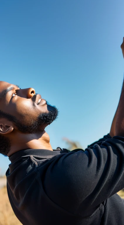 Rear view of a black man looking up at the sky on dry land