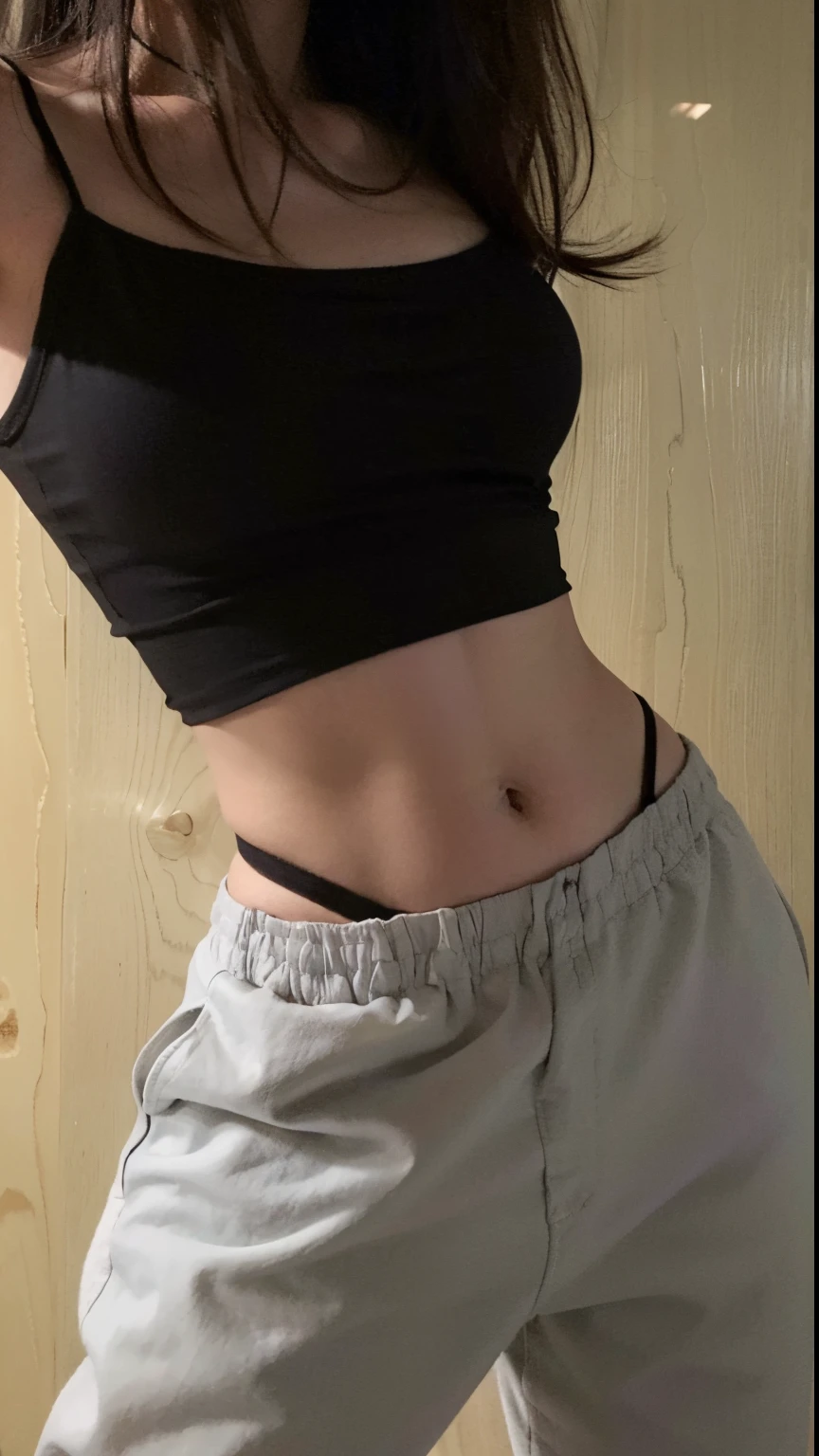 Arafed woman wearing a black top and gray pants holding a cell phone, her belly button is exposed, cintura diminuta, ombligo mostrando, Foto en forma, cintura delgada, Foto de Slim Girl, cintura delgada, cintura delgada, cintura delgada, [ rigidly defined in a delicate figure, tinyest midriff ever