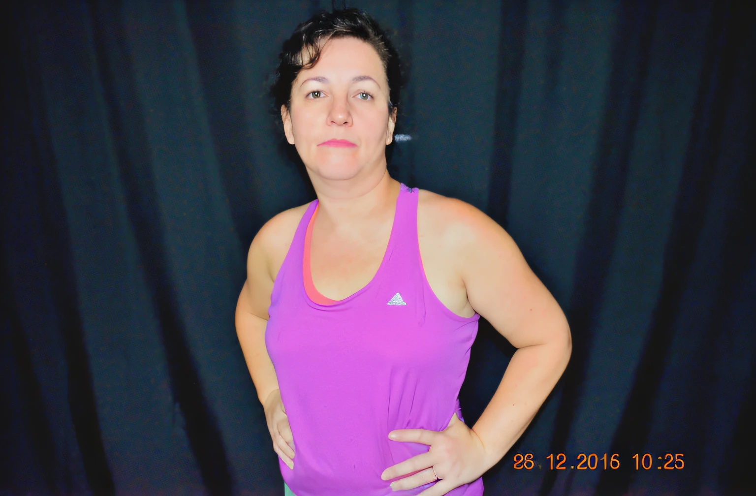 smiling woman in pink blouse flexing arms in front of black backdrop, arms extended, photo from behind, ombro na frente pose, mid 2 0's female, arms to side, 3 0 anos mulher, metade feito, toned arms, Sandra Chevier, mid-transformation, Mulheres de 40 anos, 3 6 anos, with arms up