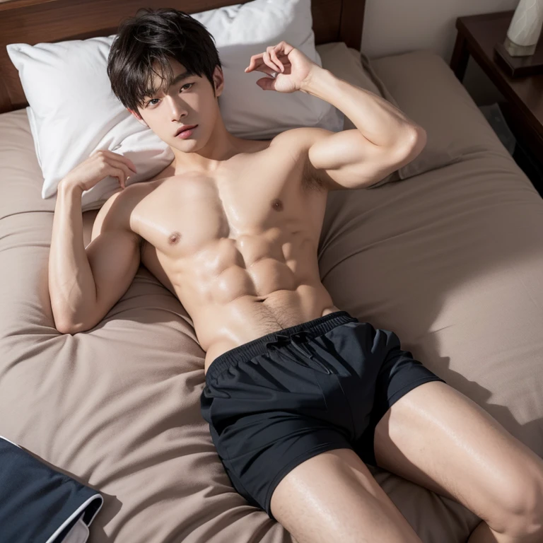 Dark-haired schoolboy in swimming trunks lying on bed