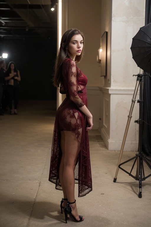 Ailina is standing with her back to the camera, head turned over her shoulder, looking back with a soft smile. One arm is draped across her lower back, and the other hand rests gently on her hip. The focus should be on her graceful silhouette and the contrast of the red garter set against the dark background.