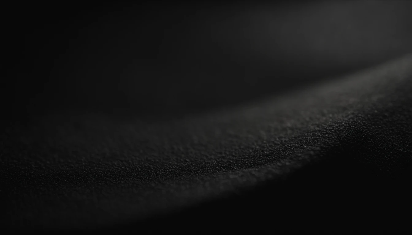 a detailed macro shot of the texture of an empty black wall, focusing on the fine grain and subtle imperfections that give it character and depth