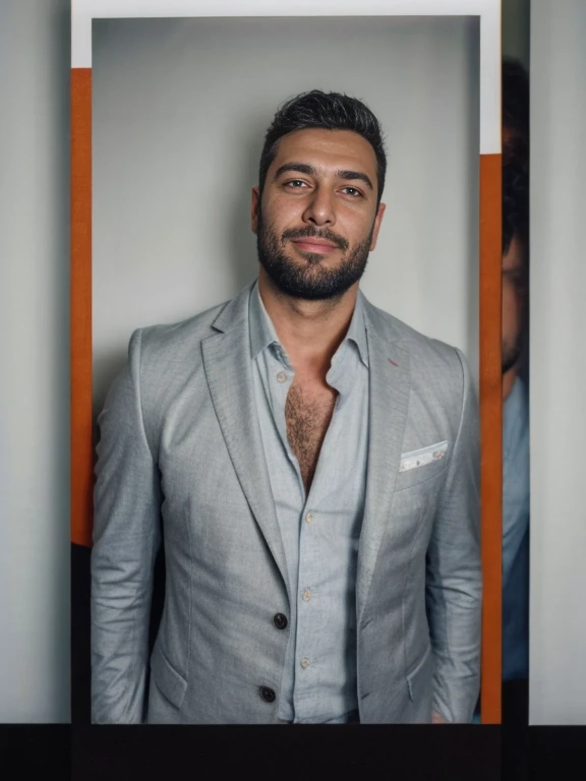 analog style, a hunky turkish man in a grey suit, handsome, stubble beard,