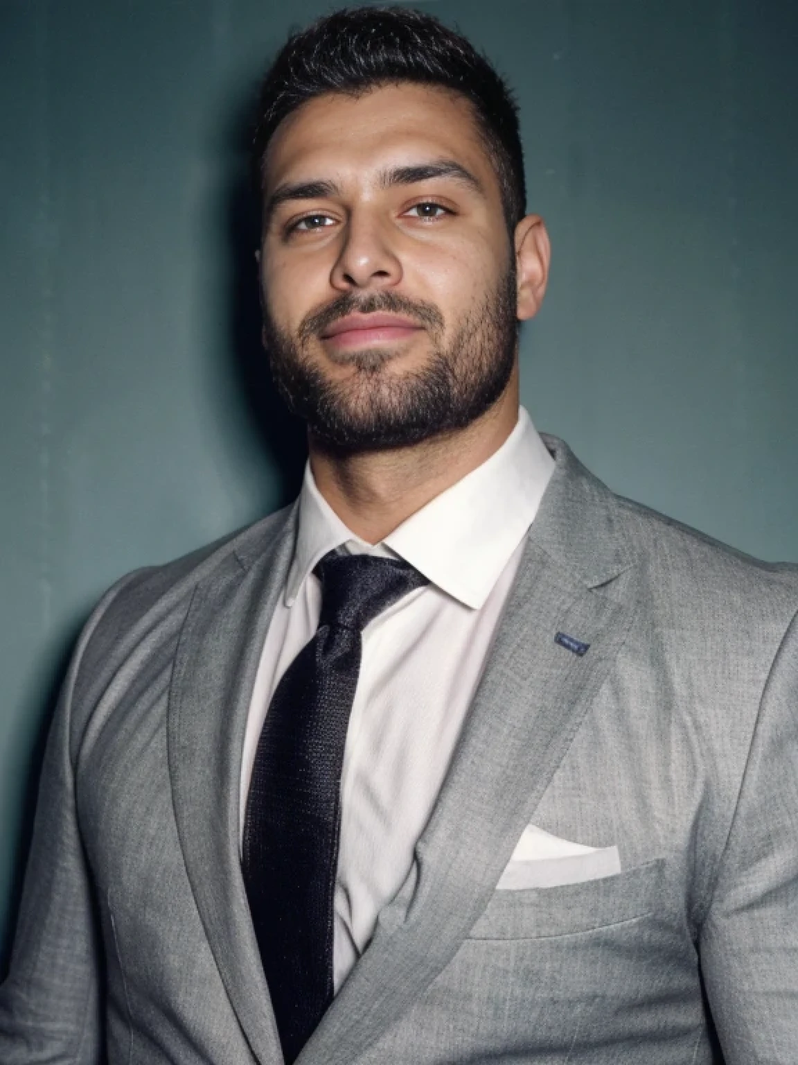 analog style, a hunky turkish man in a grey suit, handsome, stubble beard,