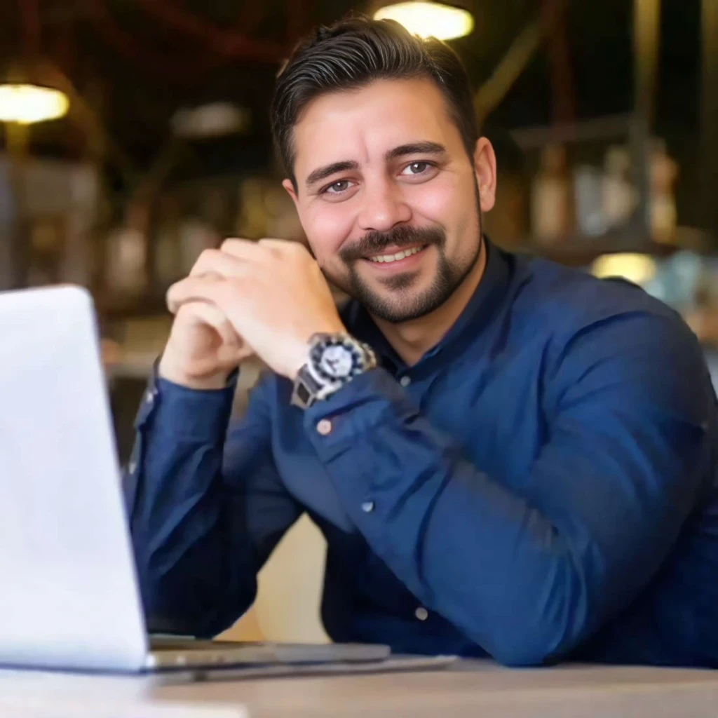 (office background:1.5), Homem branco, (barba longa:1.2), barba lenhador, barba cheia, barba volumosa, barba grande, careca, pouco cabelo, olhos claros, shy smile between open, Homem sentado em uma mesa com um laptop, blusa azul marinho, imagem de perfil, foto profissional, imagem profissional, homem na casa dos 35 anos, imagem de perfil profissional, Postagem no Reddit, codificador criativo com um computador, imagem de avatar, hiper-realista, textura realista, dramatic lighting, (melhor qualidade:1.1), profundidade de campo, HDR, profundidade de campo rasa, luz ampla, alto contraste, luz de fundo, florescer, brilhos de luz, chromatic aberration, sharp focus