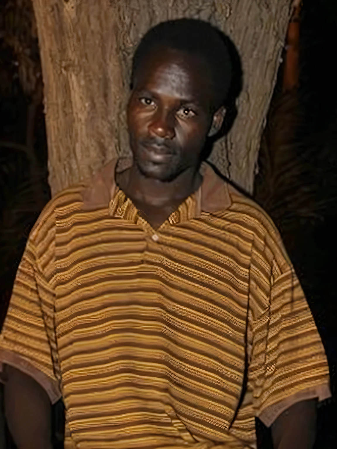 arafed man sitting in front of a tree with a laptop, edward buba, robert kinoshita, emmanuel shiru, african man, east african man with curly hair, set at night, george pemba, photo of a man, loin cloth, thomas kinkaide, a photo of a man, documentary photo