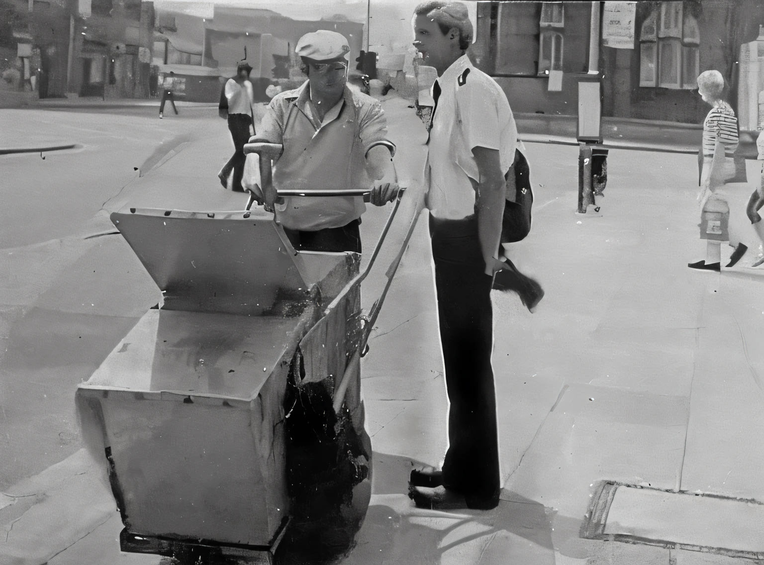 They are standing on the sidewalk with a food cart., 1 9 7 5 una foto, scene from a 1 9 7 3 film, analogue photography, Still photography, c1976, 7 0 s street photography, Photograph from 1980, photo from the 70s, 1 9 7 0 s foto, taken in the 1970s