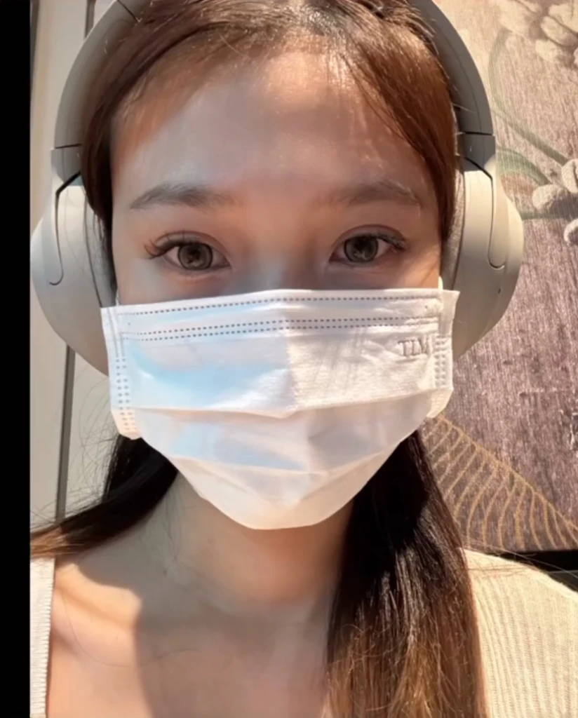 a close up of a woman wearing a face mask and headphones, the mask covers her entire face, wearing facemask, wearing mask, wearing transparent glass mask, surgical mask covering mouth, lulu chen, wearing a mask, tzuyu from twice, mask off, the robot wearing her human mask, some of them use gask mask, gemma chen,