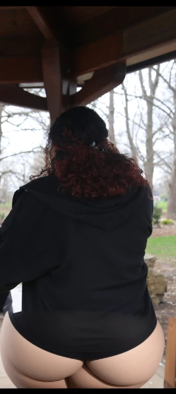 there are two people standing under a shelter talking to each other, photo still of behind view, shot from the back, view from the back, seen from the back, back of the hair, from the back, wearing a black hoodie, with curly red hair, facing away from camera, long dark curly hair, over the shoulder view, in a black hoodie, beautiful girl, big ass, huge ass, bbw, from behind, thick, thick thighs, wide hips, bbw, big tits, sideboob, giant ass, back view, big butt, round butt, tight underwear, underwear halfway off, underwear taking off, grabbing ass, ass spilling over underwear, too thick for clothes, looking left, leftwards, latina, from behind