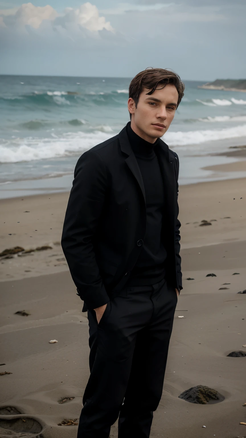 A young man dressed all in black was on the beach with his body upright and his hands in his trouser pockets looking towards the sea