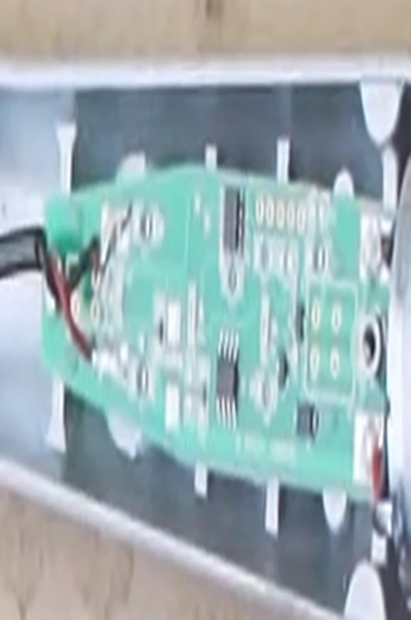 a close up of a green electronic device with a black wire, circuit board, circuit boards, circuit board artifacts, printed circuit board, assembled, [ overhead view ]!!, motherboard circuitry, electronic case display, overhead shot, top-down view, top - down view, top view, prototype, [ overhead view ]!, circuitry, circuit boards)))))