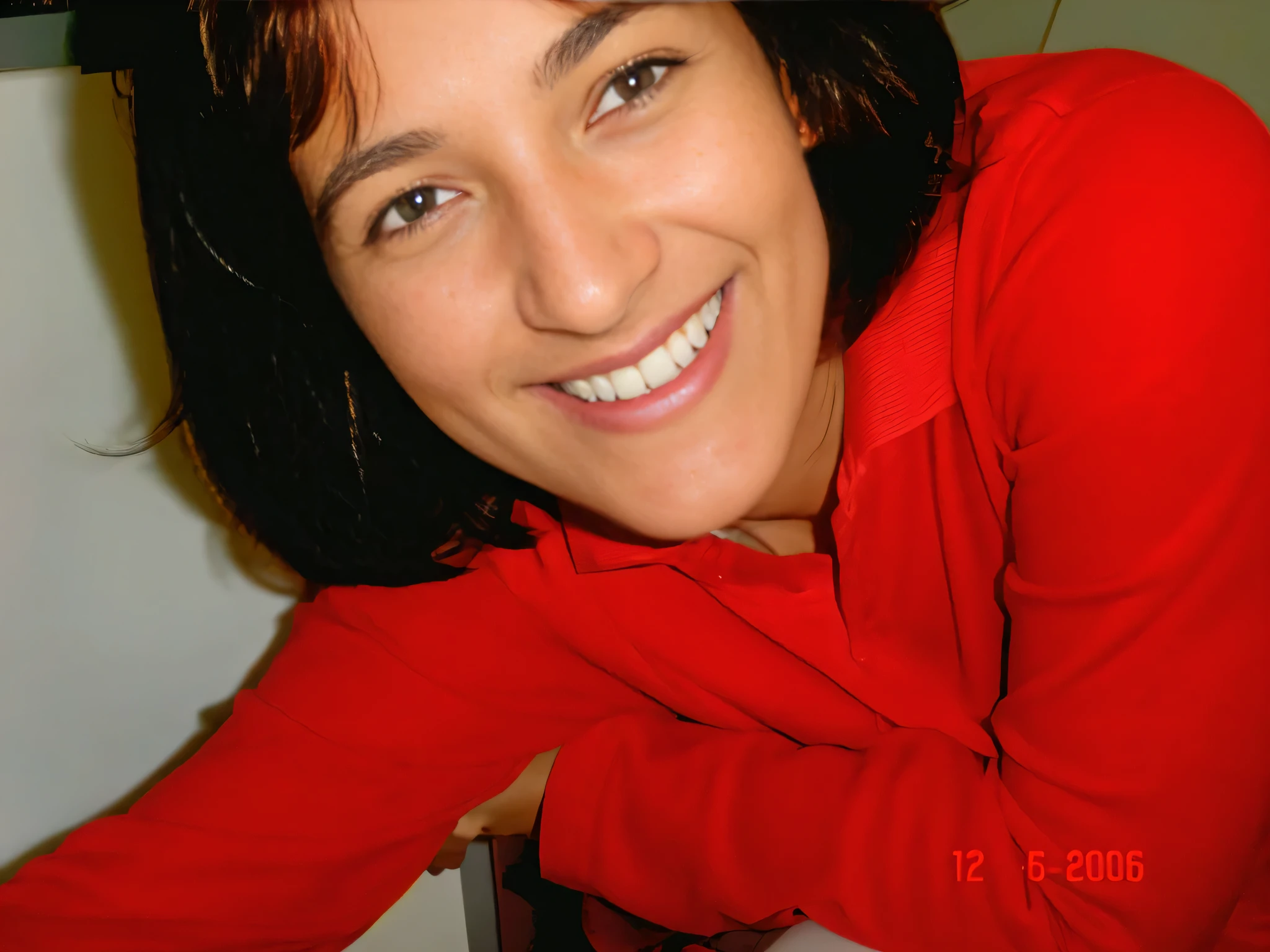 Smiling woman in a red shirt leaning against a counter with a white countertop, foto de perfil. Mulher com pele branca bronzeada e cabelos escuros. ela tem cerca de 35 anos. high resolution, alta qualidade, obra de arte, 8k. Mulher com pele branca bronzeada e cabelos escuros. ela tem cerca de 35 anos. high resolution, alta qualidade, obra de arte, 8k.