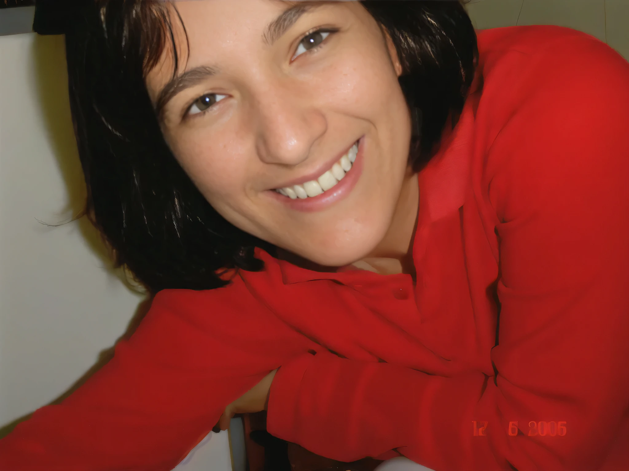 Smiling woman in a red shirt leaning against a counter with a white countertop, foto de perfil. Mulher com pele branca bronzeada e cabelos escuros. ela tem cerca de 35 anos. high resolution, alta qualidade, obra de arte, 8k. Mulher com pele branca bronzeada e cabelos escuros. ela tem cerca de 35 anos. high resolution, alta qualidade, obra de arte, 8k.