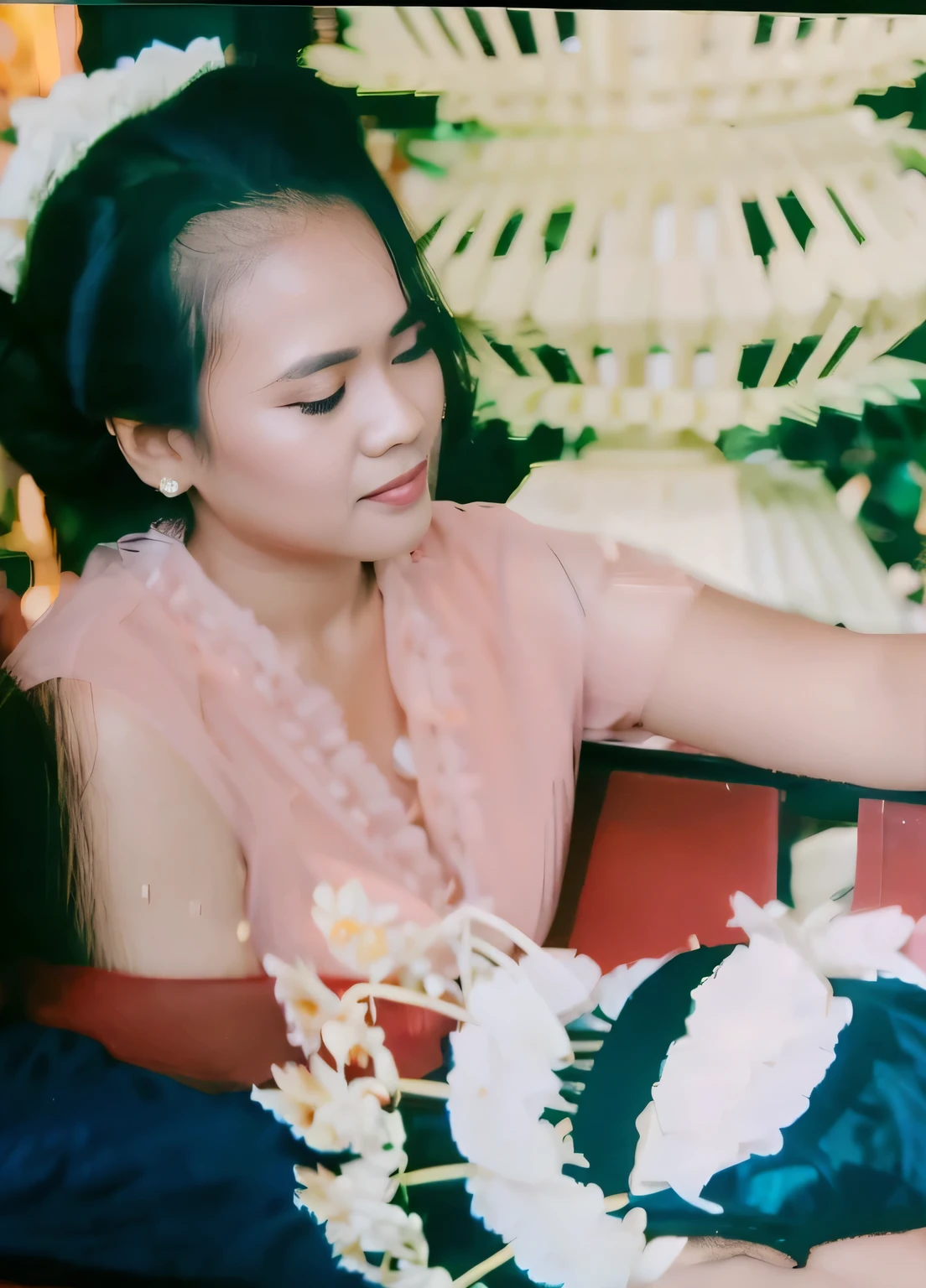 A photo of an Indonesian middle-aged woman wearing a kebaya with her hair in a bun.